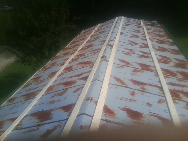 Rusted metal roof panels with new wood purlins before replacement — Storm Damage Roof Repair in Locke by Roofing Brothers