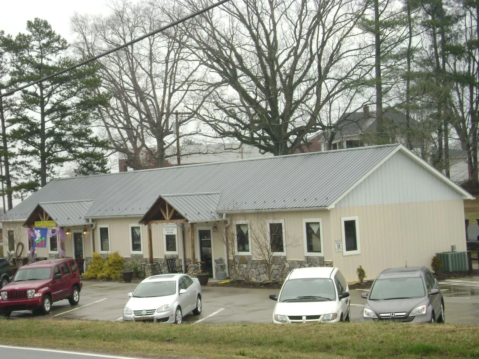 Gray metal roof with timber entry brackets on a small commercial building in Locke