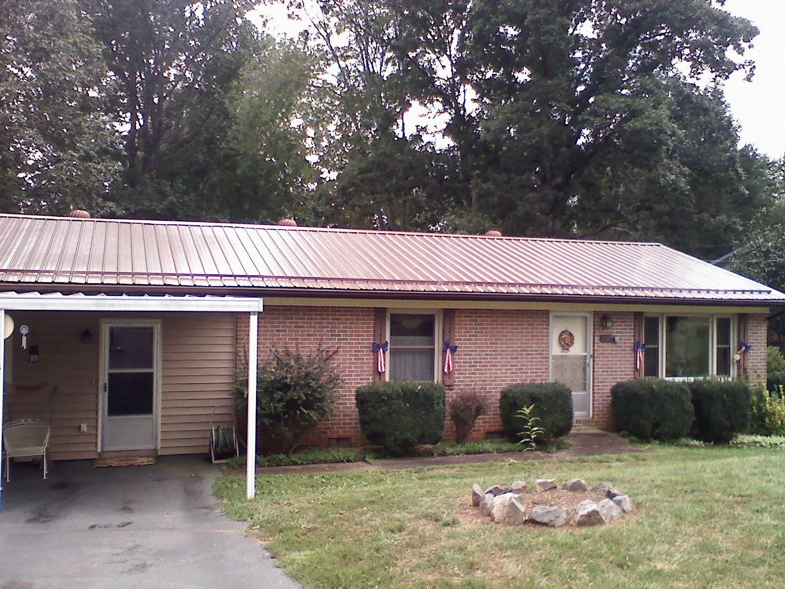 Bronze metal roof and carport on a brick ranch home — Roof Repair work by our crew in Locke